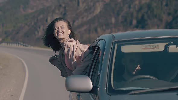 Teenage Girl in Top Looks Out of Car Smiles and Rejoices