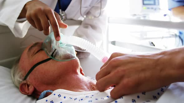 Doctor putting oxygen mask on a female senior patient face