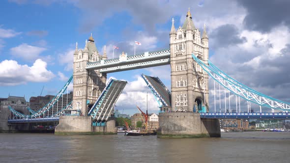 Iconic Tower Bridge in London UK Scenic Clouds Over the Lifted Bridge and Boat Going Under the