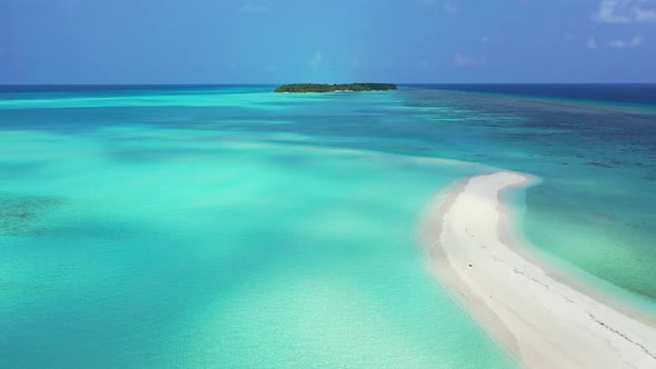 Daytime birds eye tourism shot of a sandy white paradise beach and blue ocean background in 4K