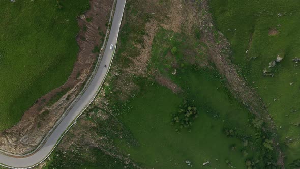 White Car Drives on a Mountain Road