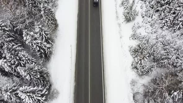 The Field Is on Top of a Snowy Road on Which Cars Drive