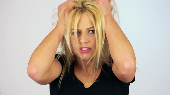 A Young Attractive Woman Trembles and Grabs Her Hair with Fury - Face Closeup - White Screen Studio