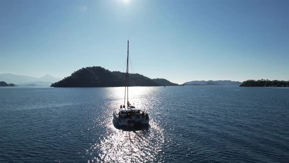 The Catamaran Yacht Sails on the Sea Towards the Island