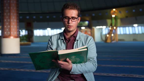 Young University Student Reading Quran in Mosque