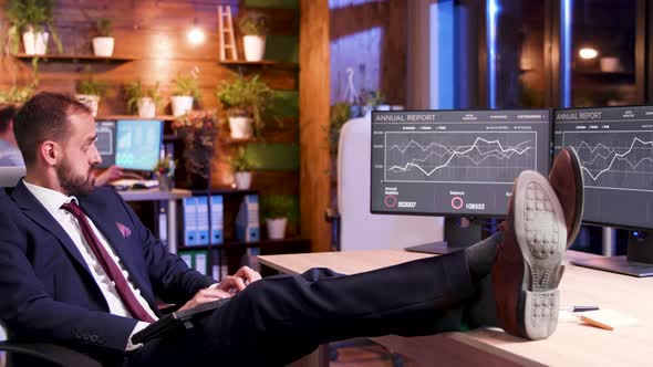 Relaxed Businessman in His Office at Night Working