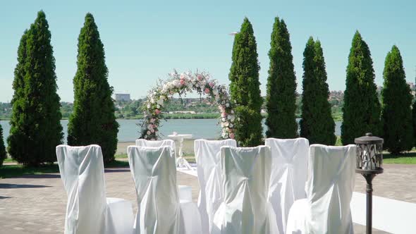 Place for bridal ceremony in white color against the background of the river. Wedding arch