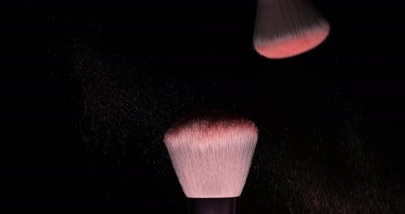 Two Makeup Brushes with Pink Powder on a Dark Background