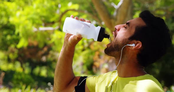 Male jogger drinking water from bottle 4k