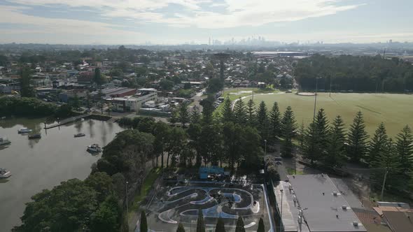 Aerial shot of urban living in Sydney suburban with housing property, roads, and park with cityscape