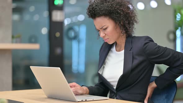 Tired African Businesswoman with Laptop Having Back Pain at Work 