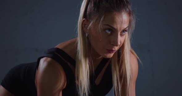 Muscular Woman Doing Exercises in the Training Room