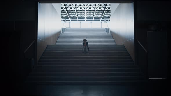 Sad Teen Boy Silhouette Sitting Alone on Stairway