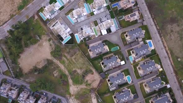 Panning wide drone shot of luxurious semi-detached chalets with pools in Madrid