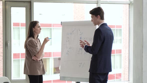 Two professional business coaches company leaders teachers give flip chart presentation 