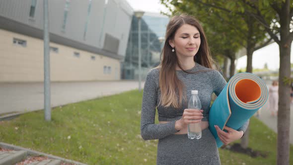 Portrait of a Young Athletic Beautiful Girl with a Rug in Her Hands and Water