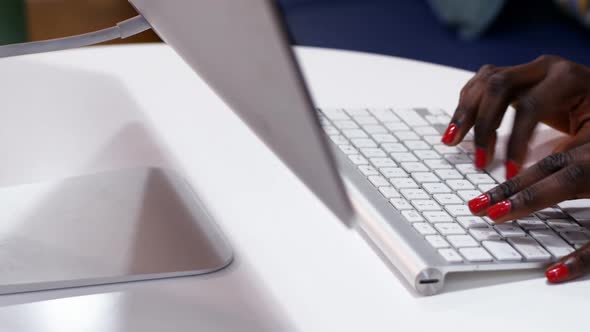 Hands of female executive typing on keyboard at desk