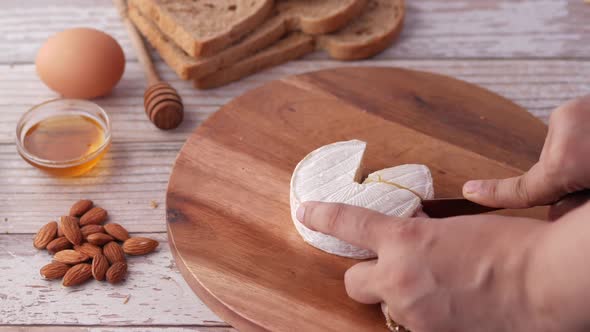 Close Up of Hand Pick a Slice of Cheese From a Chopping Board