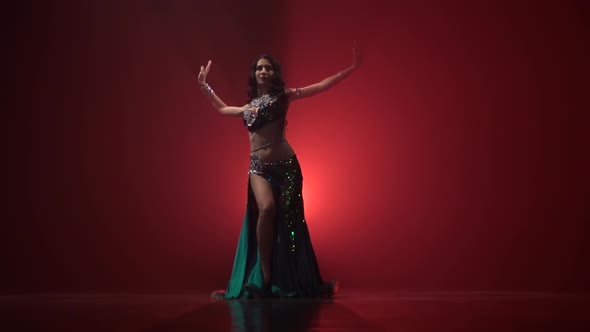 Talanted Long Haired Exotic Belly Dancer Girl Go on Dance . Red Smoke Background. Slow Motion