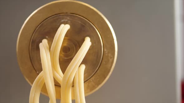 Tortiglioni Cazarece Spaghetti Pasta Falling From a Spout As They Travel Along the Production Line