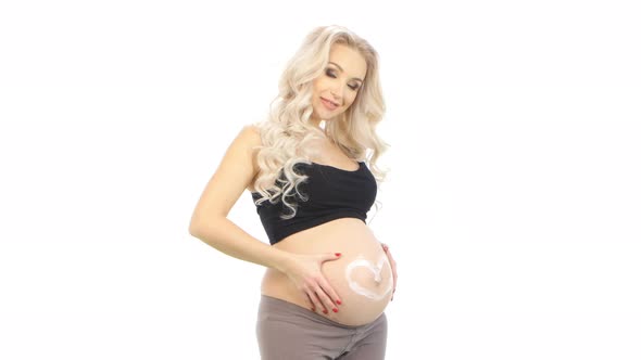 Pregnant Woman with Heart Shape on Belly Made From Cream, White