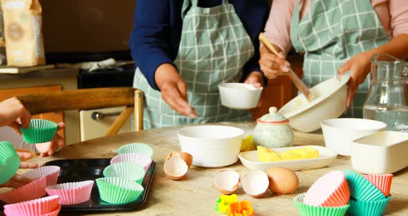 Siblings preparing food with family in kitchen 4k