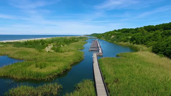 Aerial view of the long wooden promenade on a beach of Yantarny resort town, Russia