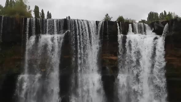 Aerial pan right shot of top of natural waterfall