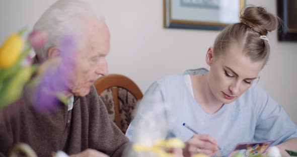 Grandfather and Granddaughter Writing Greeting Cards for Easter Holidays