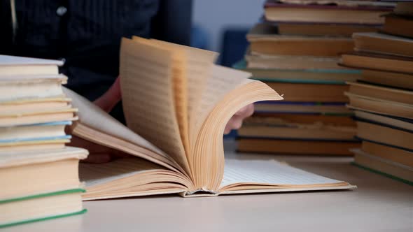 Book. Female hands leaf over the pages of old book in library. Concept of Reading and Education