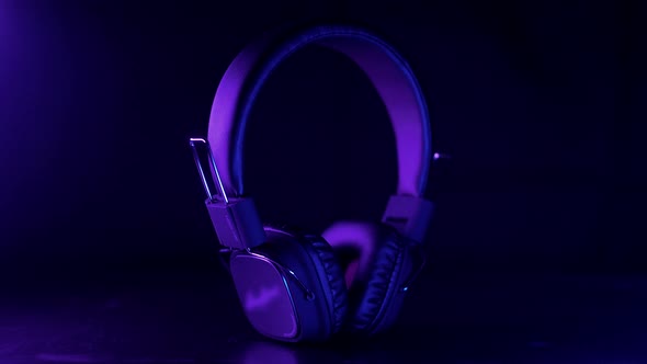 Large wireless studio headphones in violet blue dynamic light