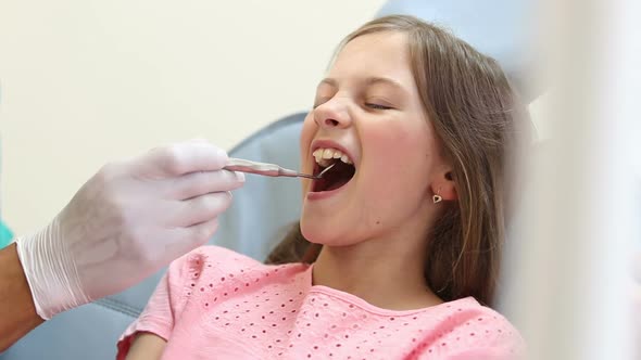 Close up of cute girl having a dental checkup with mouth mirror