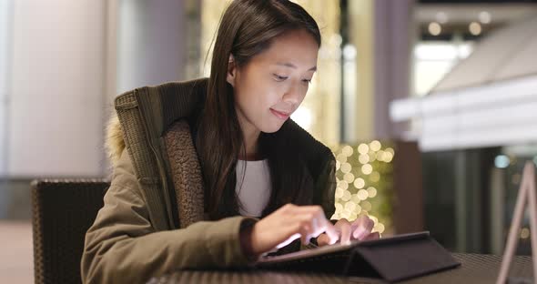 Young woman working on tablet computer at night