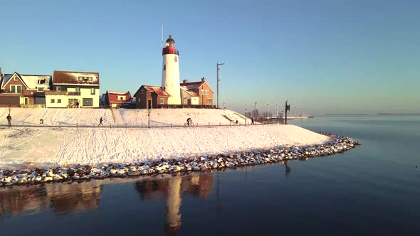 Urk Netherlands Lighthouse During Winter with Snow Covered Coastline Urk View at the Lighthouse