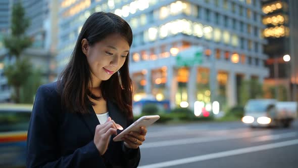 Businesswoman looking at mobile phone at evening