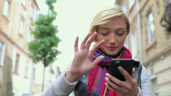 Beautiful woman using mobile phone at city street. 