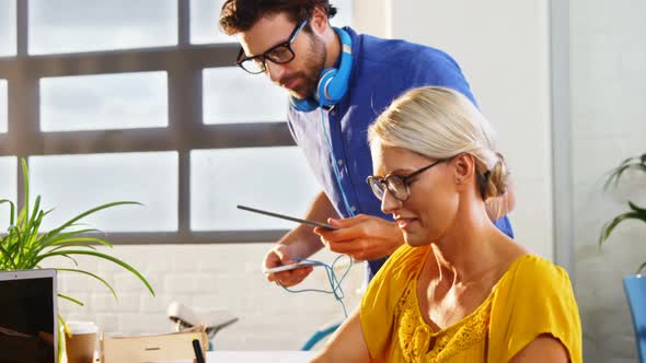 Graphic designers discussing over digital tablet