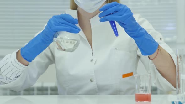 Female Scientist Analyzing Liquid In Test Tube. alt