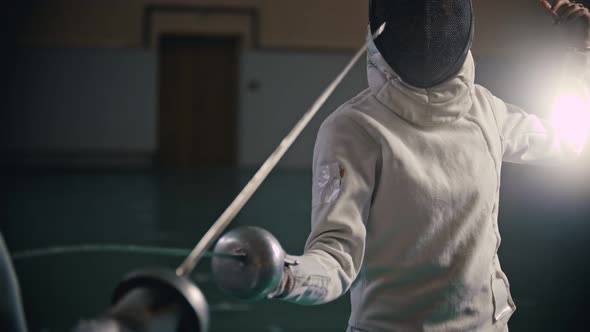 Two Young Women Fencers Having a Training in the Gym - a Woman Pokes at the Opponent