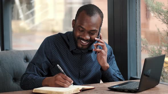 Businessman Working Remotely with Laptop at Cafe