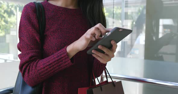 Shopping woman using cellphone at outdoor 