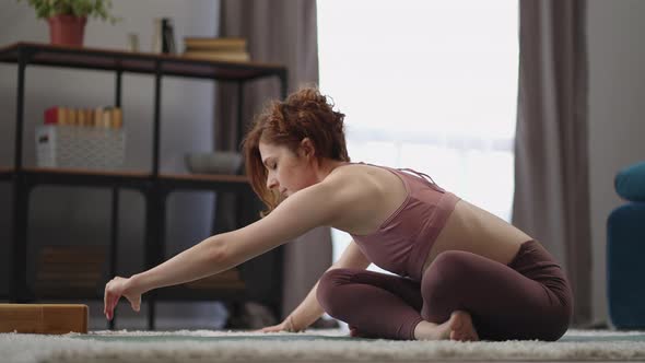 Adult Sporty Woman is Training Alone in Living Room Morning Workout in Apartment Practicing Yoga