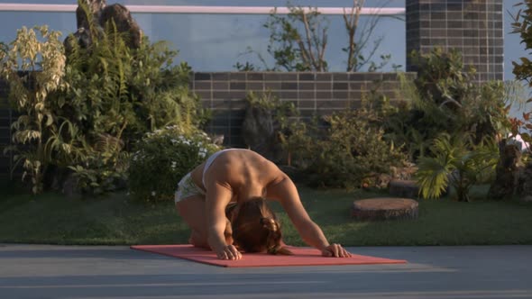 Girl Does Yoga Relaxing Exercises on Orange Mat