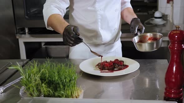 Closeup of the Chef Pouring a Juicy Beef Steak Sauce with Strawberries