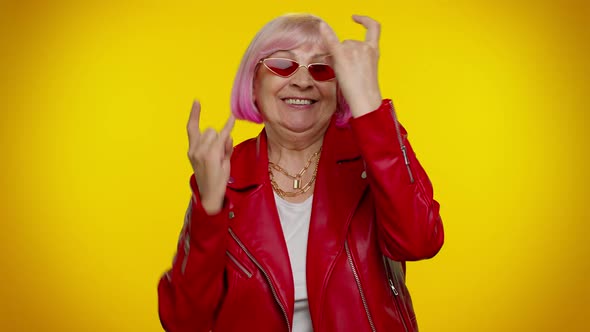 Overjoyed Delighted Crazy Elderly Woman Showing Rock n Roll Gesture By Hands Cool Sign Dancing