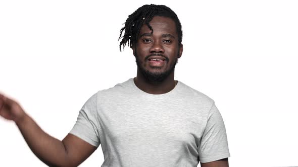 Portrait of Big African American Man with Afro Hairdo in Casual Tshirt Greeting with Waving Hand on