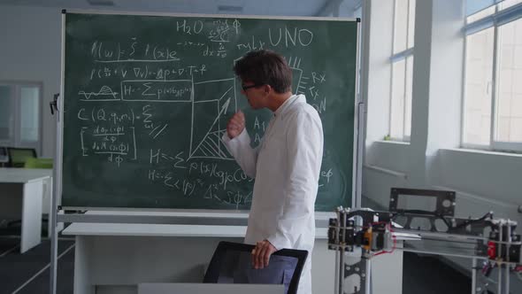 Teacher Looks on the Blackboard and That Looks on the Camera
