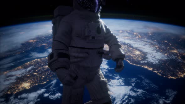 Astronaut in Outer Space Against the Backdrop of the Planet Earth