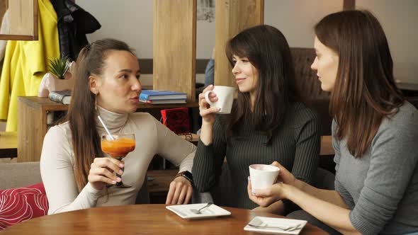 Three Girlfriends are Meeting in Cafe
