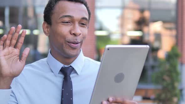 Outdoor Video Chat on Tablet by African Businessman